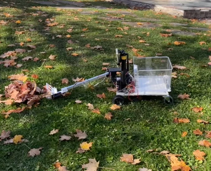 Ember prototype on grass with the arm extended in front of its collection bin