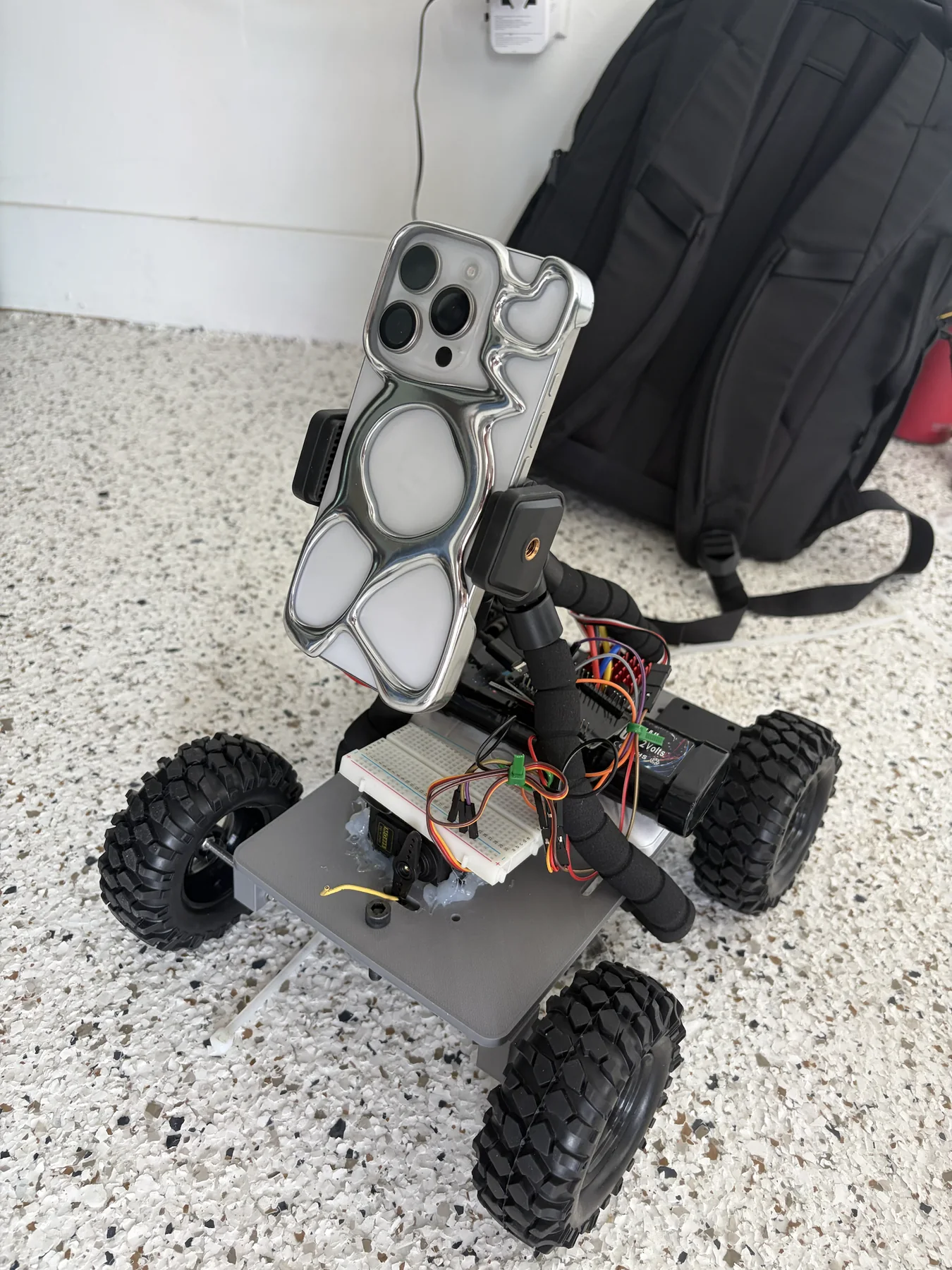 Close view of Spark rover wiring, steering servo, ESP32 controls, and phone capture mount